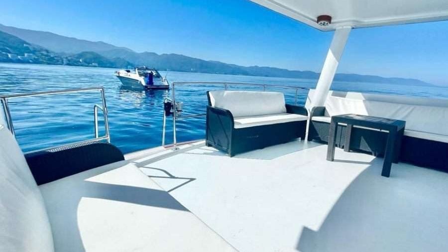 Cubierta superior con sala y toldo del yate Californian 50 frente a la costa de Puerto Vallarta, charter de yate privado para grupos